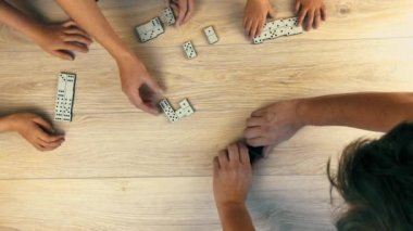 Baba çocuklarına domino oynamayı öğretiyor. Flet lei. Yukarıdan ateş ediliyor. 
