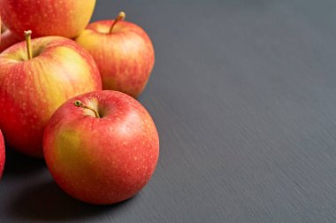 Vitamin dolu taze elmalar yığını mutfaktaki eski, koyu çizik beton masanın üzerinde yatıyor. Hasat ya da diyet konsepti. Metin için boşluk