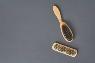 Temizlik bezi, ayakkabı, halı veya diğer tekstil ürünleri için ahşap saplı iki fırça koyu renkli beton masanın üzerinde yatar. Mesaj için yer var. Üst görünüm
