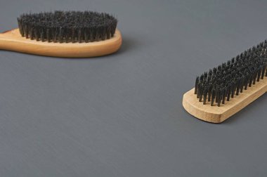 Temizlik bezi, ayakkabı, halı veya diğer tekstil ürünleri için ahşap saplı iki fırça koyu renkli beton masanın üzerinde yatar. Metin için boşluk