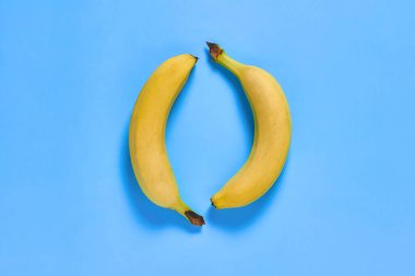 Mutfaktaki mor masada bir çift taze olgun muz. Sağlıklı gıda konsepti. Üst Manzara. Yakın plan.