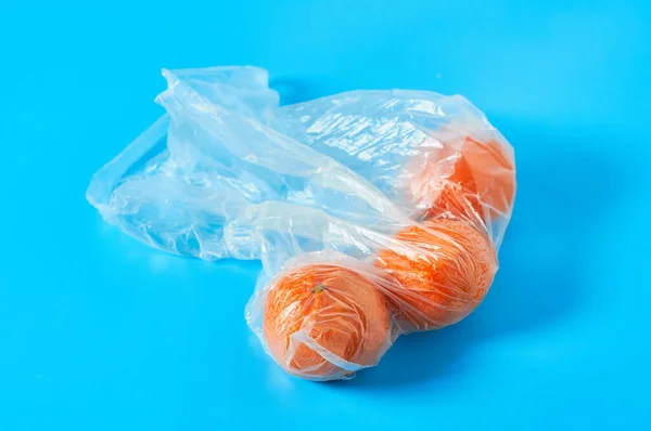 青を基調としたポリエチレン製の袋の中にみかんやオレンジを新鮮に 果物の購入の概念 — ストック写真