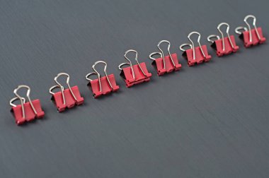 Ofiste, okulda ya da evde koyu beton masa üzerindeki kağıtlar için kırmızı metal klasörler. Metin için boşluk