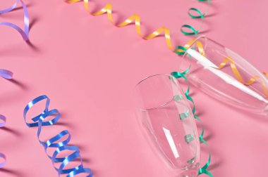 Sarmal kurdelelerin yanında alkol için iki boş bardak pembe masanın üzerinde yatıyor. Metin için boşluk