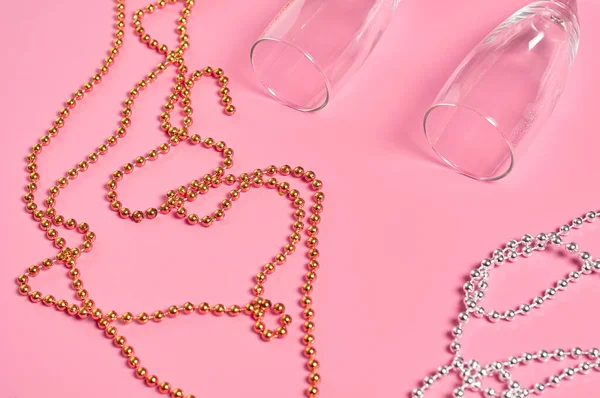Розовом Столе Лежат Два Пустых Стакана Алкоголя Рядом Ожерельями Золотого — стоковое фото