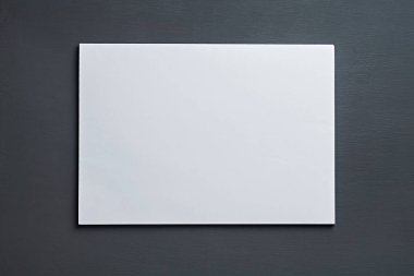 Tek yığın beyaz kağıt, sekreterin, müdürün, patronun ya da diğer şirket çalışanlarının işyerindeki koyu beton masanın üzerinde yatar. Mesaj için yer var. Üst Manzara. Yakın plan.