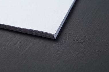 Temiz beyaz kağıt çarşaf yığınının köşesi, sekreterin, müdürün, patronun ya da diğer şirket çalışanlarının işyerindeki koyu beton masanın üzerinde uzanıyor. Metin için boşluk
