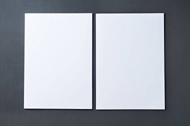 İki boş beyaz kağıt yığını, sekreterin, müdürün, patronun ya da diğer şirket çalışanlarının işyerindeki koyu beton masanın üzerinde yatıyor. Mesaj için yer var. Üst Manzara. Yakın plan.
