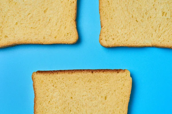Три Квадратні Шматочки Жовтого Ванільного Хліба Тостів Лежать Синьому Столі — стокове фото