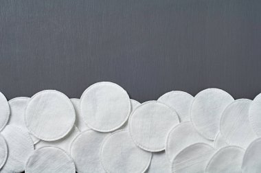 Hijyen için etrafa saçılmış pamuk pedleri koyu beton masa üzerinde yatar. Mesaj için yer var. Üst görünüm