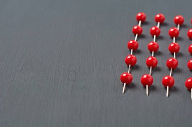 Ofisteki, okuldaki ya da evdeki koyu beton masa üzerindeki kırmızı raptiyeler. Metin için boşluk
