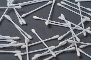 Hijyen için bir sürü yeni pamuk çubuğu koyu beton masanın üzerinde yatıyor. Yakın plan.