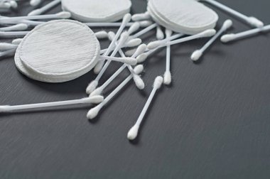 Dağınık temiz pamuk pedleri ve sopalar koyu beton masanın üzerinde. Metin için boşluk