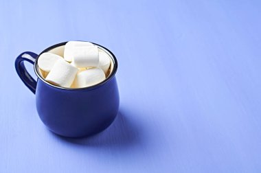 Mor çizik beton masa üzerinde tam mavi seramik şekerli, beyaz silindirik silindirik bir kap. Metin için boşluk