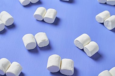 Birçok dağınık çift beyaz şekerlemeler mor çizik beton masa üzerinde yatar.