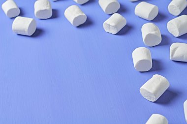 Bir sürü dağınık beyaz şekerlemeler mor çizik beton masa üzerinde yatar. Metin için boşluk