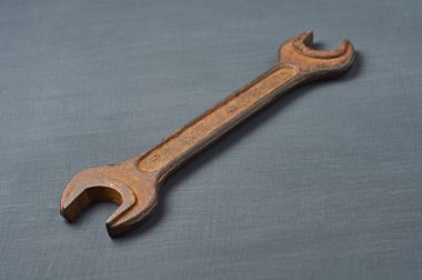 Çerezler için eski paslı ve dağınık anahtar koyu betonun üzerinde yatıyor.