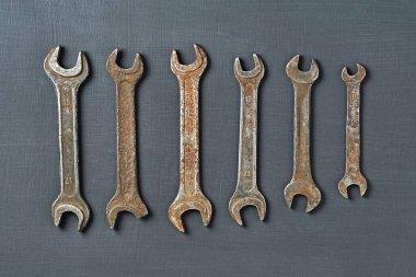 Fındıklar için paslı ve paslı anahtarlar koyu betonun üzerinde yatıyor. Üst görünüm