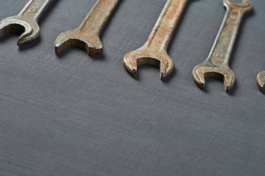 Fındıklar için paslı ve paslı anahtarlar koyu betonun üzerinde yatıyor. Metin için boşluk