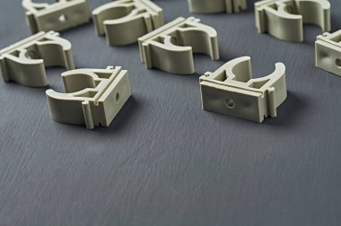 Birçok dağınık modern plastik kıskaç su için polipropilen boru ve ısıtma odası çalışma odasındaki koyu beton masa üzerinde yatar. Metin için boşluk