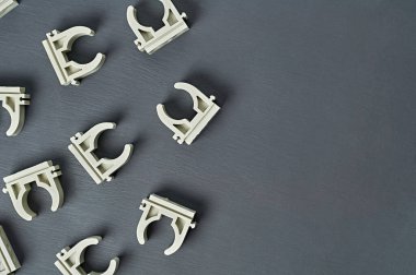 Birçok dağınık modern plastik kıskaç su için polipropilen boru ve ısıtma odası çalışma odasındaki koyu beton masa üzerinde yatar. Mesaj için yer var. Üst görünüm