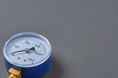 Hava veya gaz basıncını doğru ölçmek için mavi manometre atölyedeki koyu beton masanın üzerinde yatar. Metin için boşluk