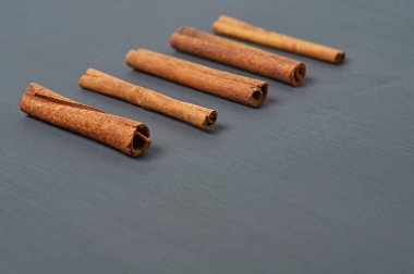 Beş aromalı tarçın çubukları, mutfaktaki koyu çizik masanın üzerinde duruyor. Metin için boşluk