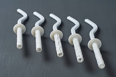 Alüminyum dağı için beyaz yeni modern kancalar ya da ısıtma evi için bimetalik kaloriferler atölyedeki koyu çizik beton masa üzerinde uzanıyor. Ev idaresi konsepti. Yakın plan.