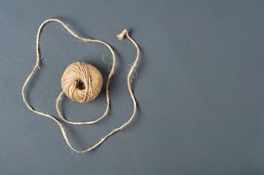 Kahverengi ip topu atölyedeki koyu beton masanın üzerinde yatıyor. Mesaj için yer var. Üst görünüm