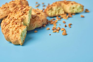 Mutfaktaki mavi masanın üzerinde fıstıklı ve kırıntılı taze yuvarlak yulaf kurabiyeleri duruyor. Metin için boşluk