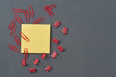 Ofisteki, okuldaki ya da evdeki koyu beton masaya not almak için boş kare kağıdın yanına bir sürü dosya ve ataç serpiştirdim. Mesaj için yer var. Üst görünüm