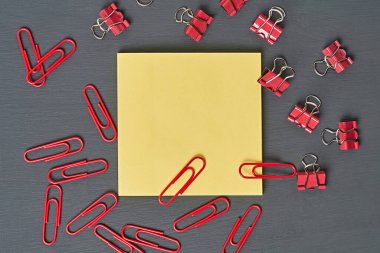 Ofisteki, okuldaki ya da evdeki koyu beton masaya not almak için boş kare kağıdın yanına bir sürü dosya ve ataç serpiştirdim. Mesaj için yer var. Üst görünüm