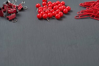 Ofisteki, okuldaki ya da evdeki koyu beton masa üzerindeki kağıt yığınları, ataçlar ve raptiyeler. Metin için boşluk