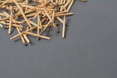 Mutfaktaki koyu beton masaya yanmış sülfür ile bir sürü kullanılmış kibrit çöpü serpiştirdim. Metin için boşluk
