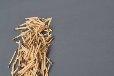 Mutfaktaki koyu beton masada yanmış sülfürlü bir sürü kullanılmış kibrit çöpü. Metin için boşluk