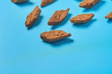 Dağınık kahverengi baharatlı rusk ekmeği parçaları spor barında ya da barda mavi masanın üzerinde yatar. Metin için boşluk