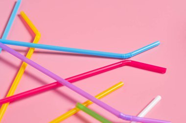 Pembe masadaki içecek için rengarenk pipetler. Metin için boşluk