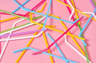 Pembe masadaki içecek için rengarenk pipetler. Yakın plan.