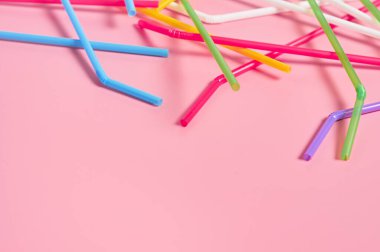 Pembe masadaki içecek için rengarenk pipetler. Metin için boşluk