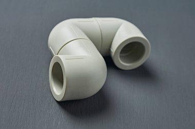 Polipropilen, su veya diğer sıvılar için plastik boru hattı koyu beton üzerine kuruludur. Yakın plan.