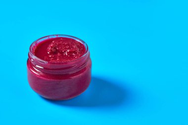 Mutfaktaki mavi masada bir kavanoz taze baharatlı yaban turpu duruyor. Metin için boşluk