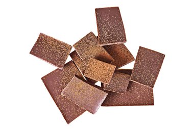 Bir sürü kırık çikolata parçası koyu acı ya da sütlü çikolata serpiştirilmiş beyaz arka planda gölgeler olmadan izole edilmiş toz kakao. Üst görünüm