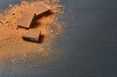 Koyu çizikli beton masaya saçılmış bir yığın acı ya da sütlü kakao tozu. Metin için boşluk