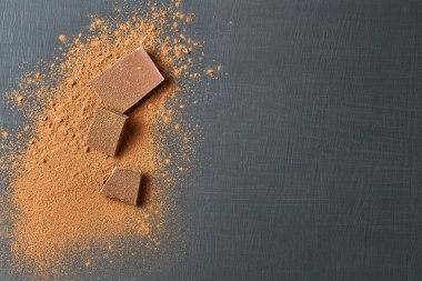 Koyu çizikli beton masaya saçılmış bir yığın acı ya da sütlü kakao tozu. Mesaj için yer var. Üst görünüm