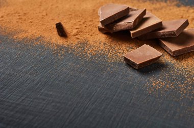 Koyu çizikli beton masaya saçılmış bir yığın acı ya da sütlü kakao tozu. Metin için boşluk