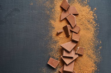 Koyu çizikli beton masaya saçılmış bir yığın acı ya da sütlü kakao tozu. Mesaj için yer var. Üst görünüm