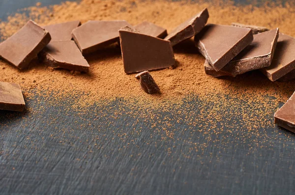 Koyu çizikli beton masaya saçılmış kakao tozu parçacıkları ya da sütlü çikolata tozu yığını. Metin için boşluk