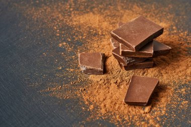 Koyu çizikli beton masaya saçılmış bir yığın acı ya da sütlü kakao tozu. Metin için boşluk