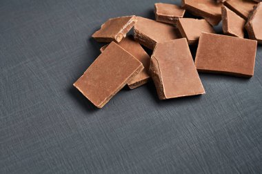 Koyu çizgili beton masaya saçılmış bir yığın acı ya da süt çikolatası.