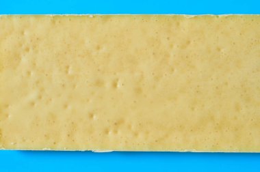 Mutfaktaki mavi masanın üzerinde beyaz gözenekli çikolata var. Üst Manzara. Yakın plan.